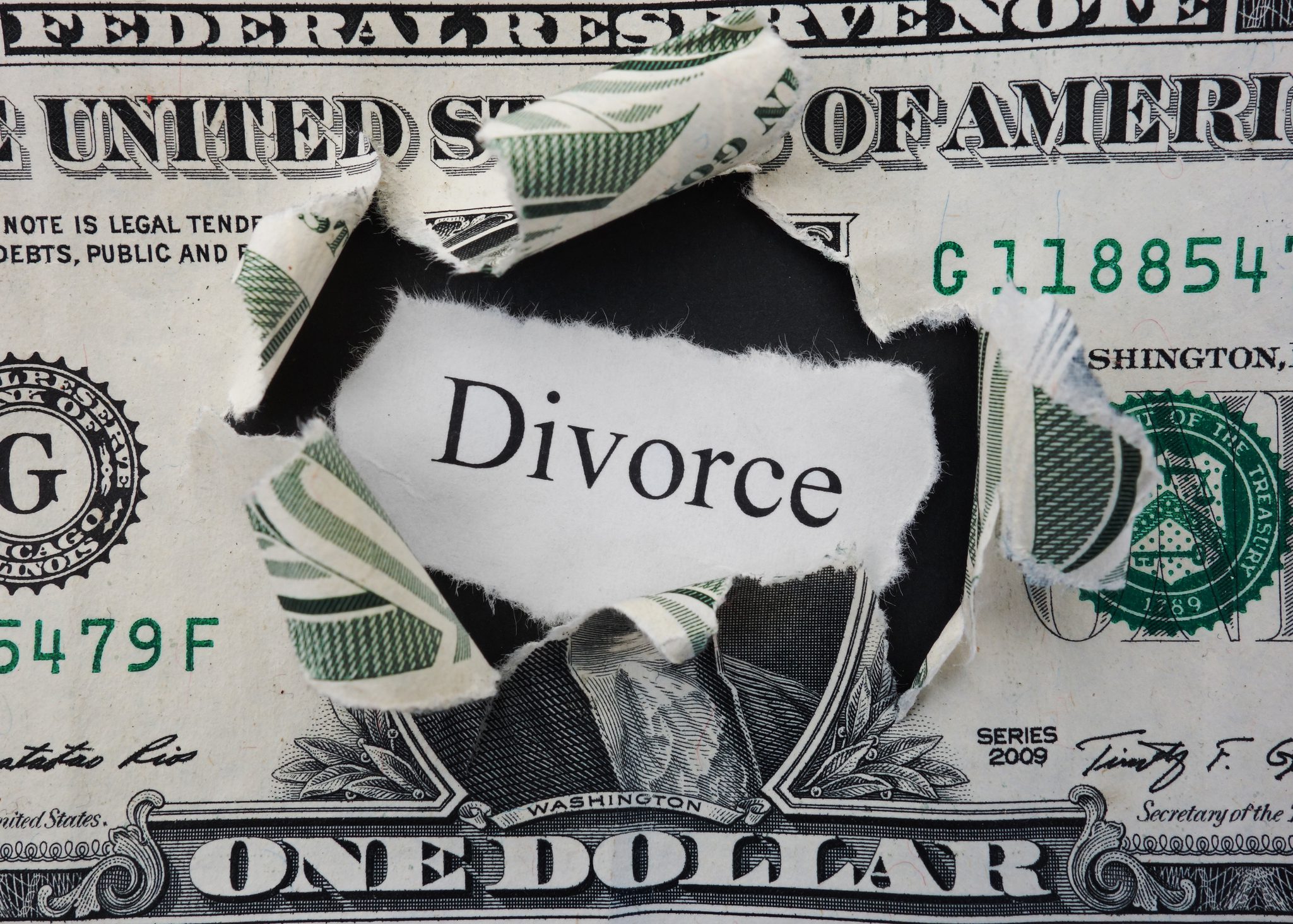 Torn dollar bill revealing the word 'Divorce'.